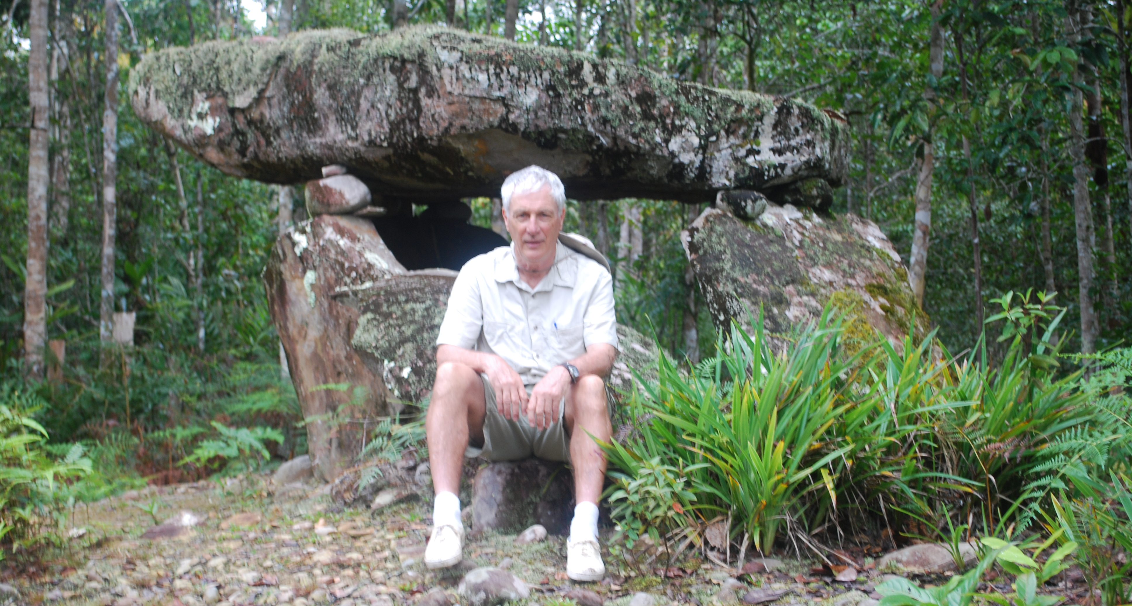 Paul Malone sitting in front of a megalith at Palungan